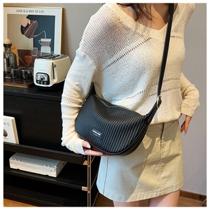 Detail of black pleated crossbody bag with Fashion & Bags logo and leather texture