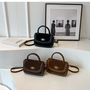 Trois sacs bandoulière vintage en daim noir et marron sur un socle d'exposition