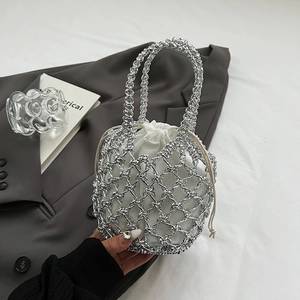 Close-up of silver metallic woven handbag with white drawstring inner pouch and tassel