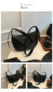 Close-up of black half-moon shoulder bag featuring vertical pleated textures and gold hardware