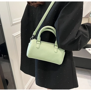 Detail of mint green pleated small crossbody bag with silver hardware and shoulder strap