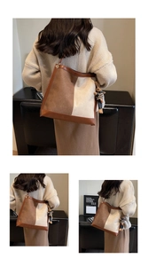 Detail of large contrast tote bag with brown leather straps and a cute bear bag charm