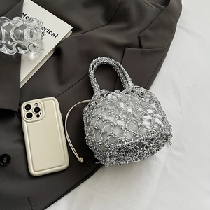 Detail of silver metallic crochet mesh tote bag with a white drawstring inner pouch