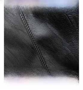 Macro detail of high-quality black leather tote with white double-stitched seam design