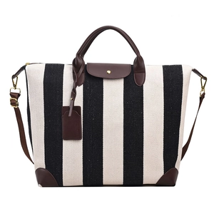 Grand sac de voyage en toile à rayures noires et blanches avec bordure en cuir marron et sangle