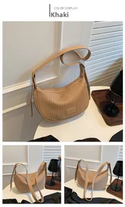 Detailed close-up of khaki pleated crescent bag with textured faux leather and adjustable strap