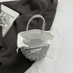 Detailed view of silver woven mesh bucket bag with white drawstring lining and handle