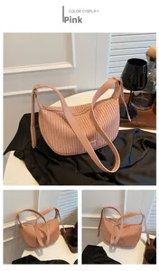 Detail of pink pleated crescent bag showing soft faux leather texture and adjustable strap