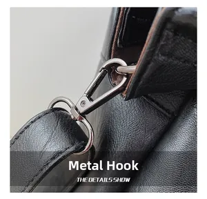 Macro detail of gunmetal hardware hook and leather strap stitching on black tote bag