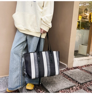 Lifestyle shot of large striped canvas tote bag in black white and grey for daily use