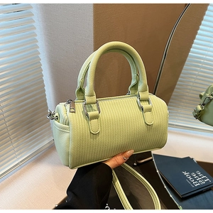 Close-up of light green pleated Boston bag with woven texture and silver hardware