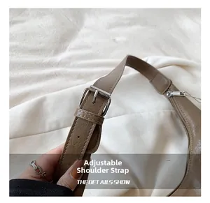 Detail of adjustable brown faux leather shoulder strap with silver buckle on tote bag