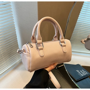 Detail of pink cylindrical Boston bag with wavy texture and silver metal hardware