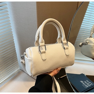 Detail of cream white leather boston bag with vertical stitching and silver hardware