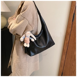Detailed view of black large capacity hobo shoulder bag with a cute rabbit plush pendant