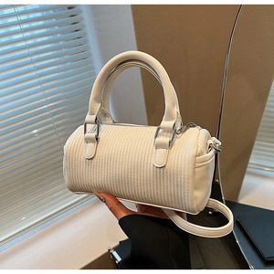 Close-up of white pleated pillow bag with embossed texture and silver hardware