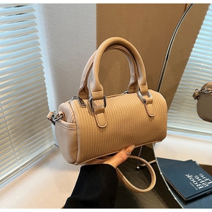 Detail of warm beige Boston bag with woven texture, dual handles and crossbody strap