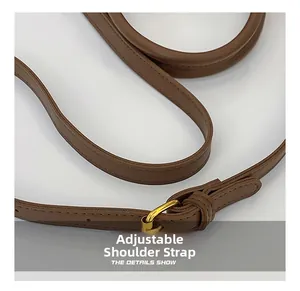 Détail de la bandoulière réglable en cuir marron avec boucle en métal doré poli