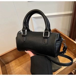 Close-up of black pleated cylinder bag featuring premium leather and silver hardware