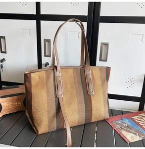 Close-up of woven fabric texture on a striped tote bag with brown leather straps