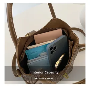Vue intérieure d'un sac seau tressé marron montrant sa capacité de rangement