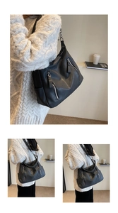 Close-up of black PU leather shoulder bag featuring silver zippers and adjustable wide strap