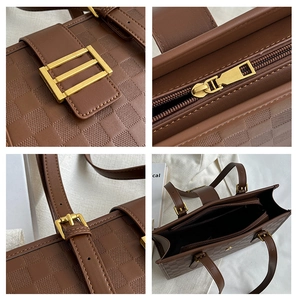 Detail of checkered embossed brown tote bag with vintage golden hardware and stitching