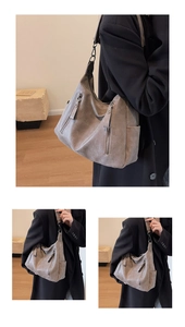 Detail view of large grey-brown tote bag with dual front zippers and side pockets