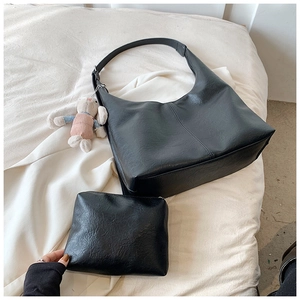 Detail of black pebbled leather tote set with matching pouch and plush rabbit charm
