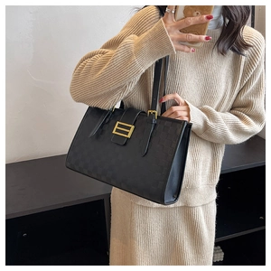 Close-up of black checkered embossed leather tote with a gold square metal buckle