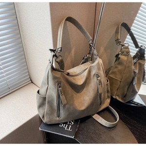 Detail of olive green tote bag with matte texture and multi-pocket functional design