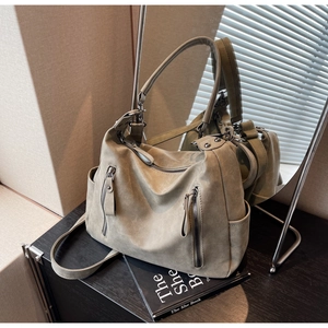 Detail of vintage olive green tote bag with matte texture and dual zipper pockets