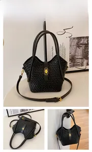 Détail d'un sac seau tressé noir montrant le fermoir doré et la texture du cuir