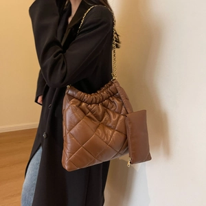Detail of brown quilted tote bag with gold chain strap and matching coin purse