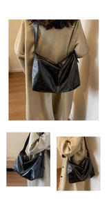 Detail van de zwarte zachte leren tote bag met geplooide textuur en brede schouderriem