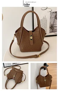 Vue détaillée d'un sac seau tressé marron avec fermoir doré et bandoulière réglable