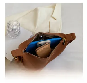 Internal view of brown litchi grain shoulder bag with notebook and accessories