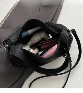 Interior view showing the large capacity of the black pleated leather handbag with essentials