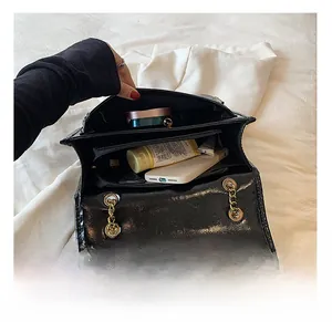 Detail view of the spacious inner compartment of the black chain shoulder bag for women