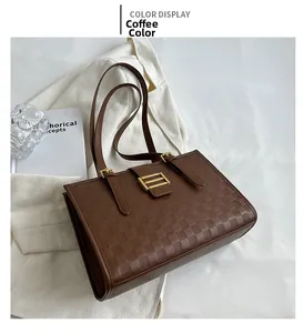 Detailed shot of coffee brown tote bag with checkered embossing and golden buckle