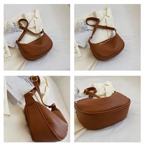 Detail view of caramel brown crescent shoulder bag with pebbled leather and gold hardware