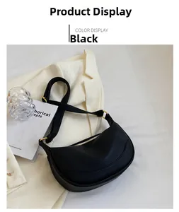 Close-up of black crescent shoulder bag with lychee texture and gold metal zippers