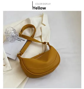 Detail of yellow crescent crossbody bag with lychee texture and adjustable shoulder strap