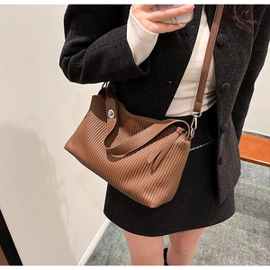 Detail of vintage brown pleated tote bag featuring silver swivel lock and textured leather