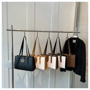 Detailed view of five checkered tote bags with gold hardware on a metal rack