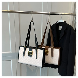 Detail of checkered tote bags with metal buckles in black and brown accents
