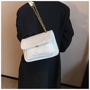 Detailed view of white chevron quilted shoulder bag with gold chain and leather strap