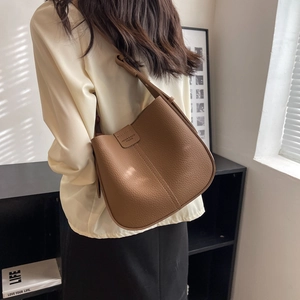 Close-up of brown litchi pattern leather shoulder bag with adjustable strap detail