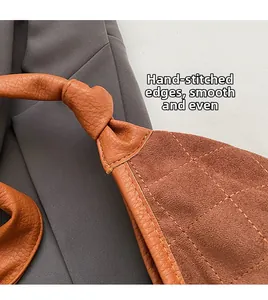 Detail of hand-stitched edging on brown leather quilted shoulder bag with smooth finish
