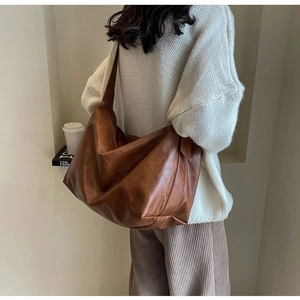 Detailweergave van een vintage bruine leren tas met zachte textuur en grote capaciteit